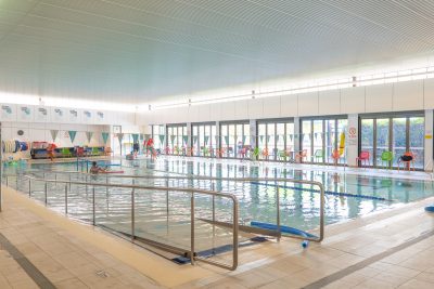 Wide shot of Beenleigh Aquatic Centre indoor pool with accessibility ramp in the centre.